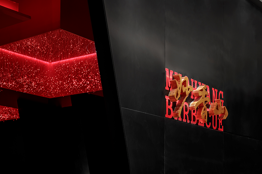 叠彩这家烤肉店的餐饮空间设计，俨然是红与黑的世界